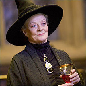 Harry Potter And The Philosopher`s Stone / Harry Potter Felsefe Taşı Filmi -  Minerva Mcgonagall- Arka planı bulanık olan kare şeklindeki fotoğrafın ortasında Minerva McGonagall (Maggie Smith), elinde bir kadehle sola doğru hafif gülümseyerek bakıyor.  MvGonagall, altmışlı yaşlarının ortasında gözüken bir kadın. Kafasında siyah bir cadı şapkası var. Cadı şapkası, bir dairenin üzerine sivri ucu yukarı bakan bir koni yerleştirilmiş bir şapkaya benziyor. Sadece şakaklarından gözüken geriye doğu toplanmış gibi gözüken gri saçları şapkanın altında kalmış. Hafif yan durduğu için sadece sağ kulağı gözüküyor.  Açık bir ten rengine sahip. Geniş ve oval bir yüzü var. Koyu renk, incecik kaşlarının altında büyük mavi gözleri uzaklara bakıyormuş gibi duruyor. Göz kapakları hafif düşmüş. Kaşlarının arasında ve göz kenarlarında kırışıklıklar belirmiş. Elmacık kemikleri belirgin. Geniş kanatlı burnundan dudak kenarlarına doğru çizgiler var. Dudakları kırmızı, ince ve kapalı halde belli belirsiz gülümsüyor. Kalın boynunda da kırışıklıklar görünüyor.  Siyah boğazlı ve önünde büzgüleri olan bir kıyafet giymiş. Boynuna büyük bir kolye takmış. Bu kolye üç şeklin alt alta birleşmiş haline benziyor. İlki siyah renkte bir su damlası, ikincisi gri metal renginde bir dikdörtgen ve üçüncüsü siyah renkte yatay şekilde duran bir oval. Üzerine yakasında dikey kesik çizgiler, geri kalan kısımlarında ise yatay kesik çizgiler bulunan siyah renkte bir cüppe giymiş. Elinde geniş ağzında altın rengi bir şerit bulunan, tutma yerine doğru daralan saydam bir kadeh var. Kadehin yarısına kadar kırmızı renkli bir içecek gözüküyor.