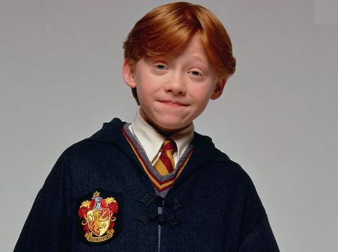 Harry Potter And The Philosopher`s Stone / Harry Potter Felsefe Taşı Filmi -  – Ronald “Ron” Bilius Weasley Arka planı gri olan yatay dikdörtgen fotoğrafın ortasında göğsünden yukarısı gözüken Ron Weasley (Rupert Grint) gülümseyerek bakıyor. 11 yaşında bir oğlan çocuğu. Yuvarlak bir yüzü var. Kırmızımsı turuncu renkte düz saçları sağ taraftan ayrılmış. İki yana doğru duruyor. Saçları kepçe kulaklarının üst kısmında son buluyor. Yok denecek kadar ince kaşlarından biri saçlarının arkasında kalmış diğeri ise hafif yukarı doğu kalmış. Yeşil renkli küçük gözleriyle doğrudan objektife bakıyor. Göz kapakları hafif düşmüş. Burnu hafif kalkık ve geniş.  Burun kenarlarından yanaklarına doğru belirsiz çizgiler var. İnce dudaklarıyla ağzı kapalı bir biçimde gülümsüyor. Çenesinin iki yanında gamzesi var. Beyaz gömleğine kırmızı sarı şeritli kravatını bağlamış. Üstüne v yakasında kırmızı ve sarı şeritleri olan gri bir süveter giymiş. Üstünde siyah okul cüppesi var. Cüppenin yakası göğsün hemen üstünde iki düğme ile birbirine bağlanmış.  Cüppenin sol göğsünde Gryffindor amblemi var. Amblem alt kısmı sivri kalkan benzeri bir şekilde. Şeklin içini dört bölüme ayrılmış ve bu bölümler sarı kırmızı renklerde. Tam ortasında şaha kalkmışa benzer bir aslan figürü var.